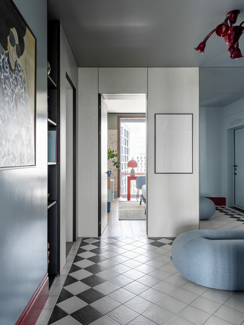 view of open hallway in modern apartment with light blue pouf in center on black and white tile floor