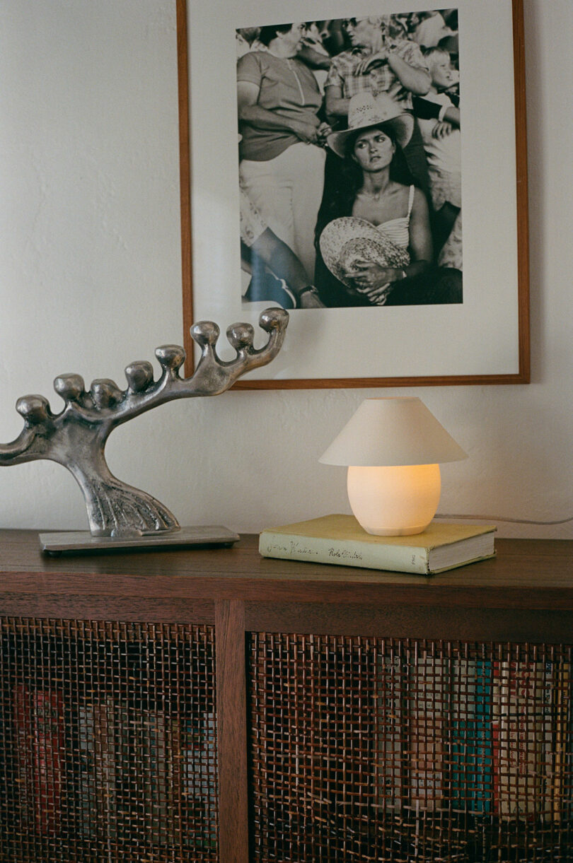 A tiny orb-shaped lamp with traditional shade sitting on a side table.