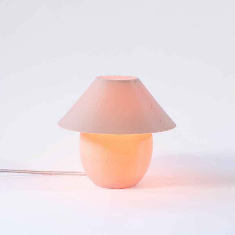 A tiny, blush colored orb-shaped lamp with traditional shade and an ambient glow.