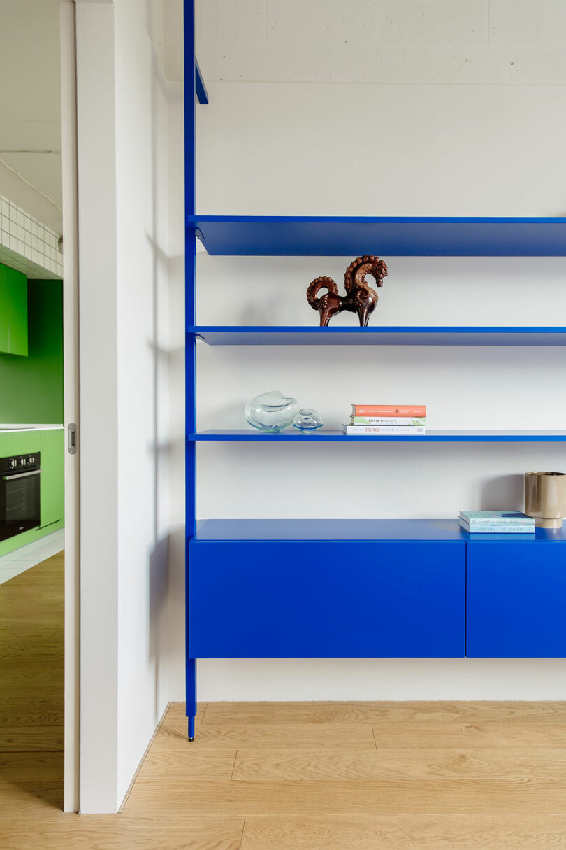 partial view of bright blue modern shelf on white wall