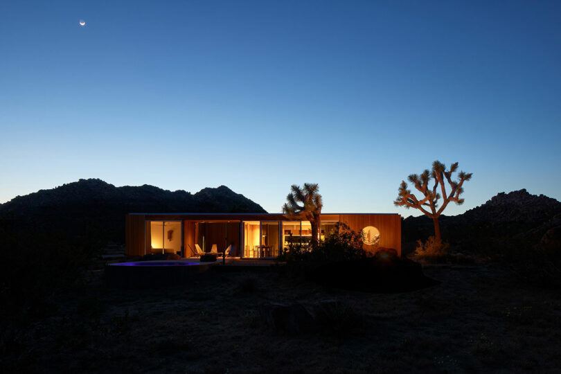 twilight outside view of modern wood pavilion style house in desert