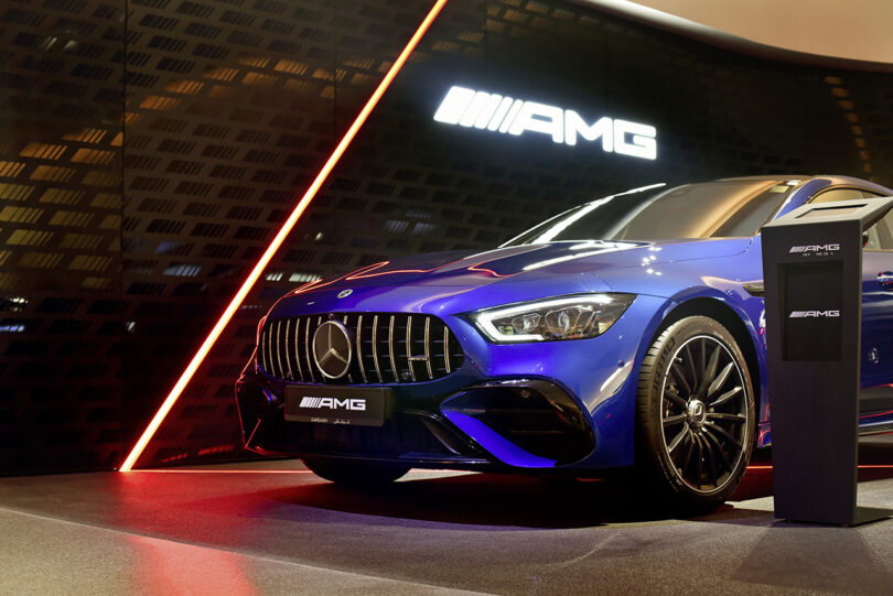 Blue AMG car parked within the Mercedes-Benz Brand Center in Dubai illuminated by an angle of red light