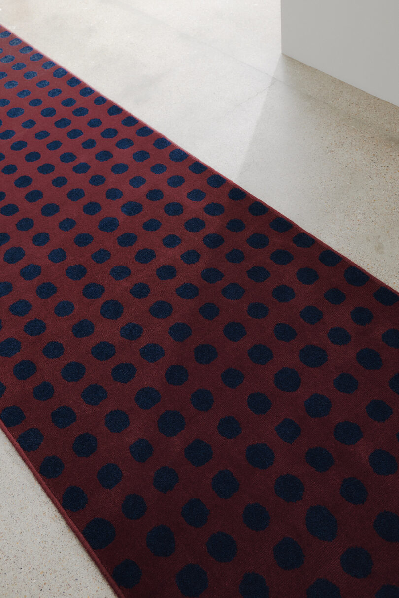 detail of black dots on red background rug pattern