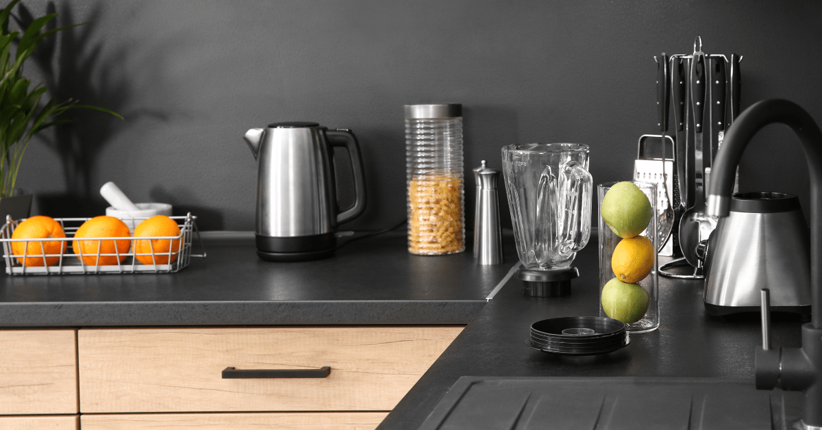 A kitchen with black countertop featuring wooden cabinets.