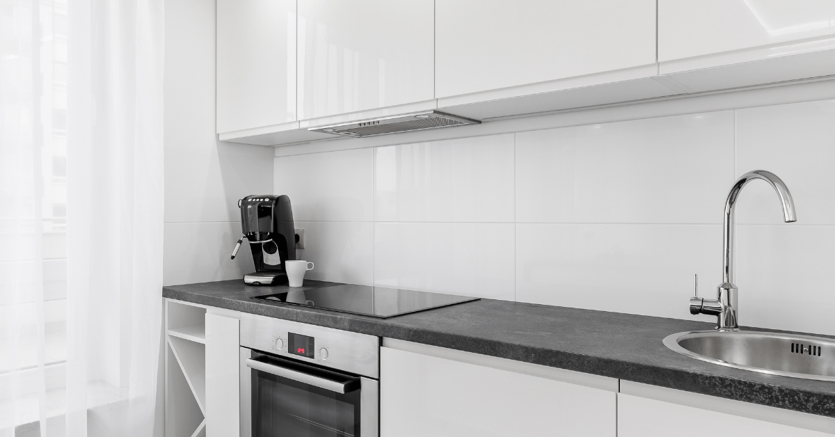 A white modern kitchen with black countertops.