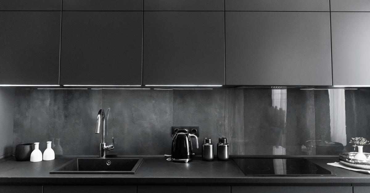 A black themed kitchen with matching black countertops.