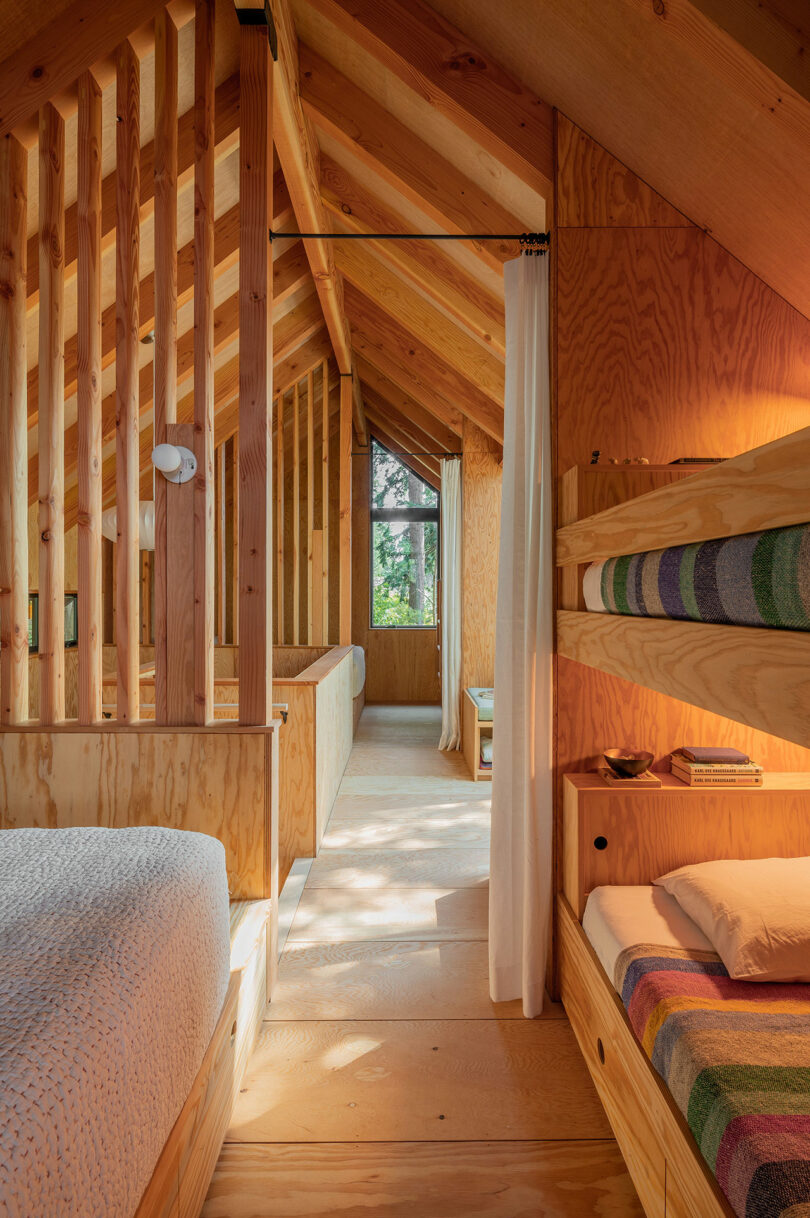interior view of modern cabin with bunkbeds on right and regular bed on left with views through to other rooms