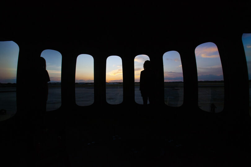 A group of people standing in front of a window on the world’s first luxury spaceflight service at sunset.