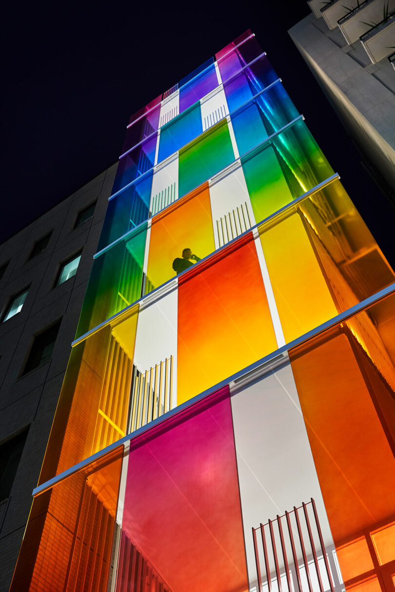 angled upward evening exterior view of modern building with rainbow fronted facade