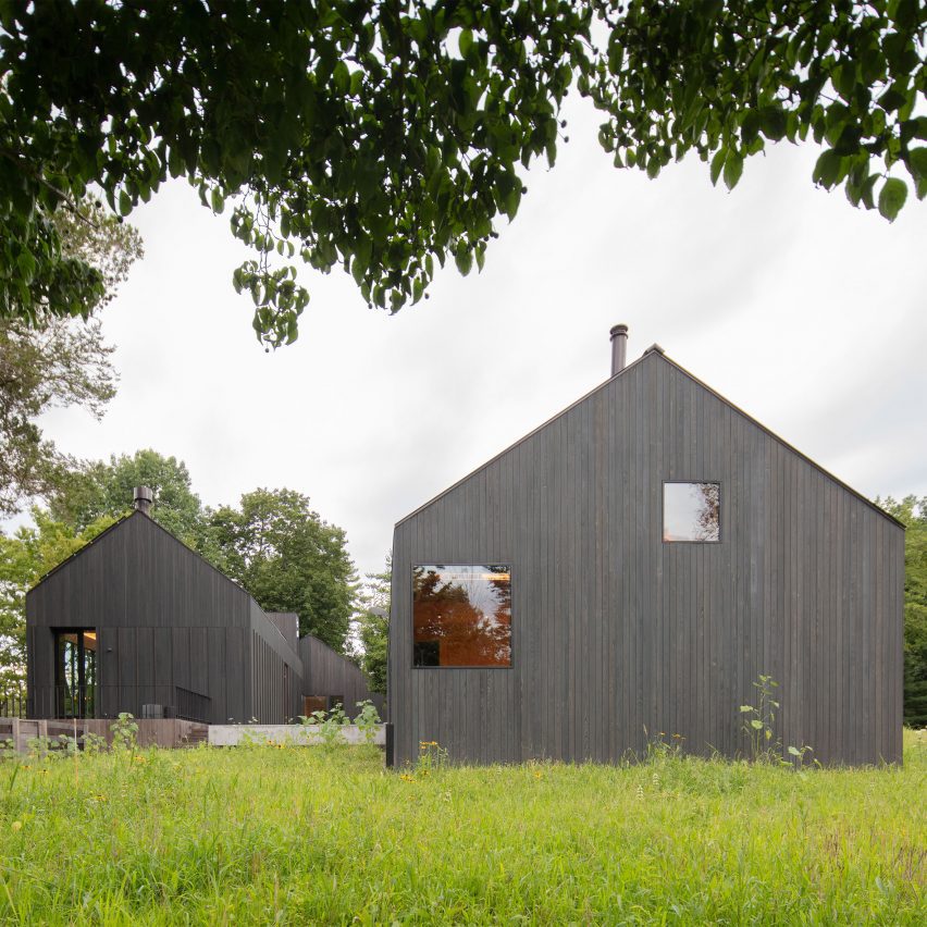 Two black timber barn-style buildings by Worrell Yeung