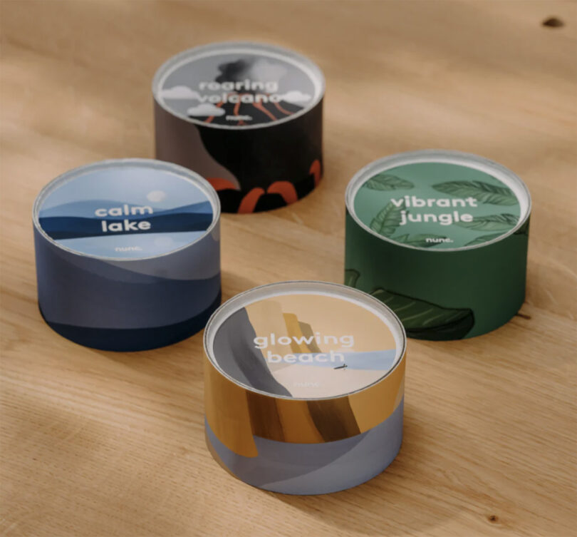 Four different nunc. coffee capsule containers with various color patterned designs sitting on top of a wooden table.