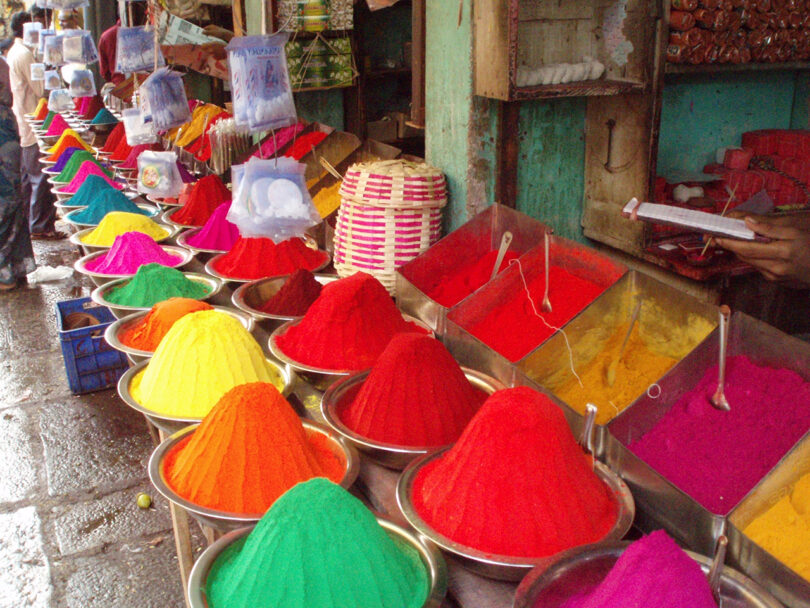 Vibrant colors of powdered dyes displayed for sale at a street market.