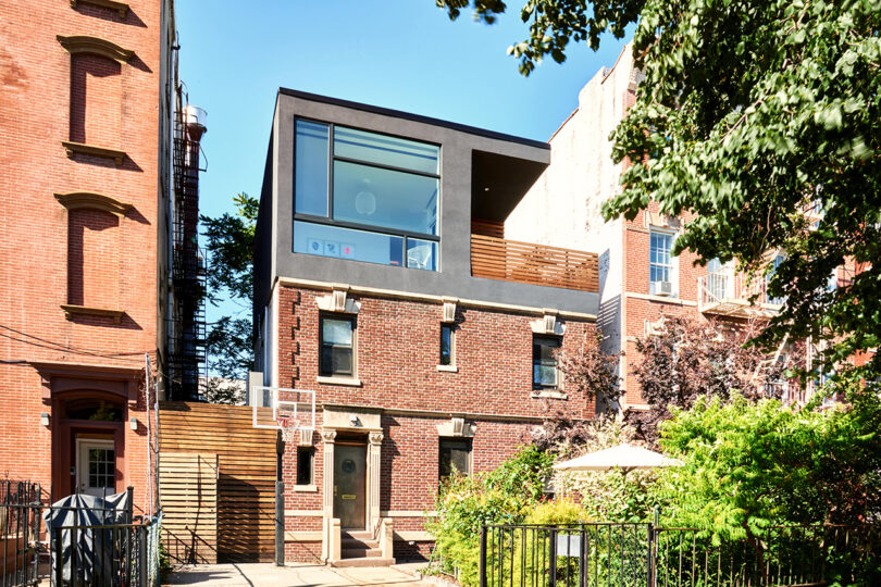Modern residential addition on a traditional brick building, blending old and new architectural styles.