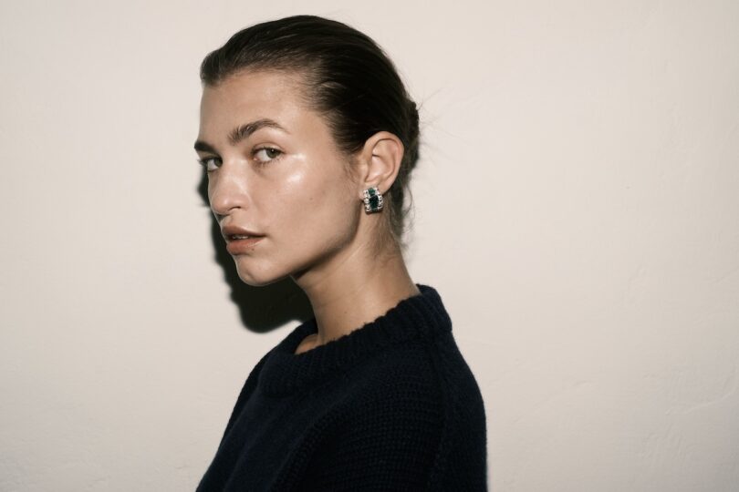 woman wearing black shirt and earring with hair slicked back