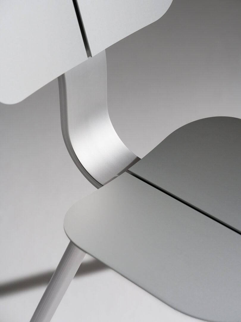 Close-up of a modern chair featuring sleek metallic curves and a minimalist design.