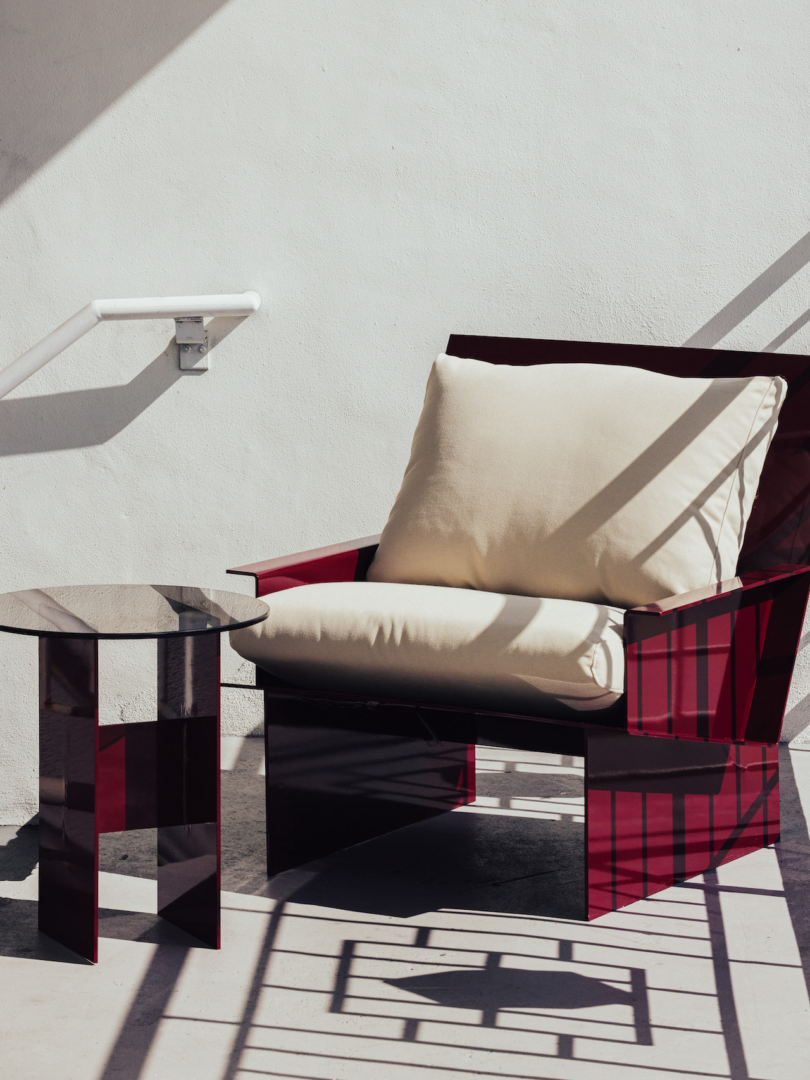 red metal chair with white upholstery and red metal table outside