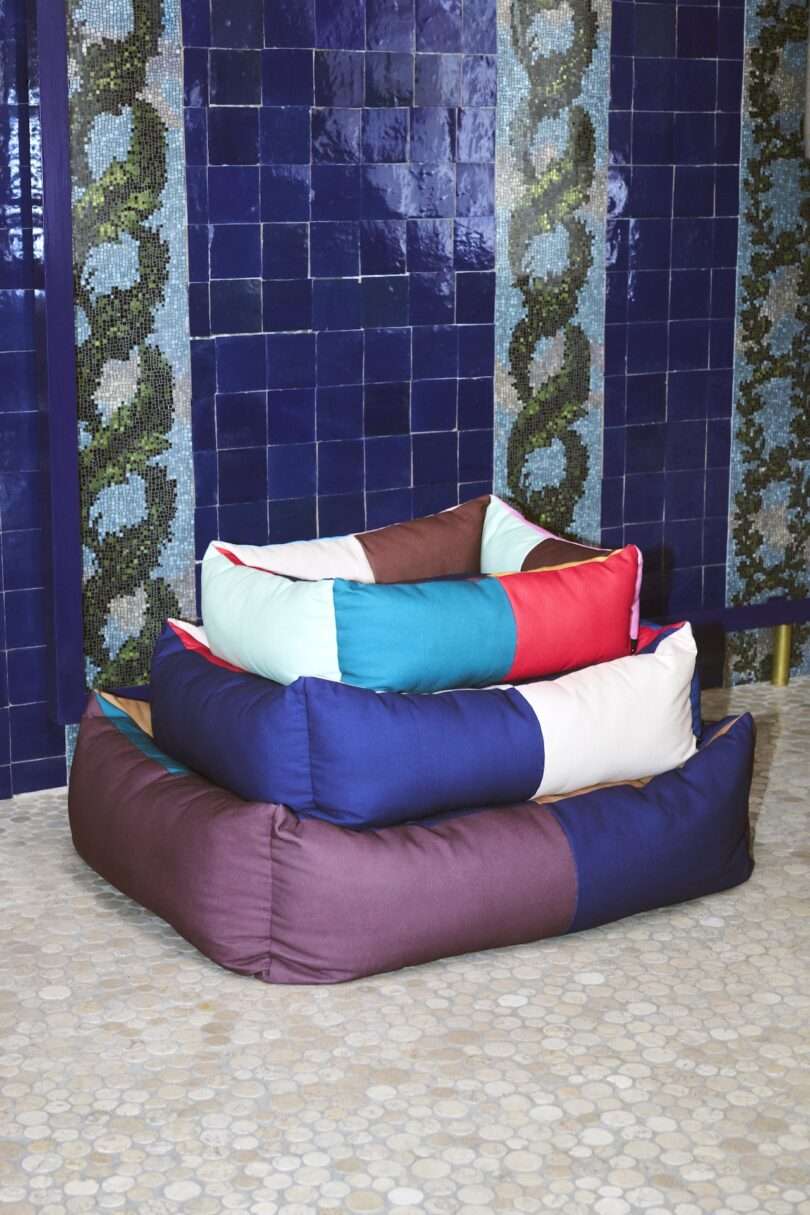 three color blocked dog beds stacked on top of each other