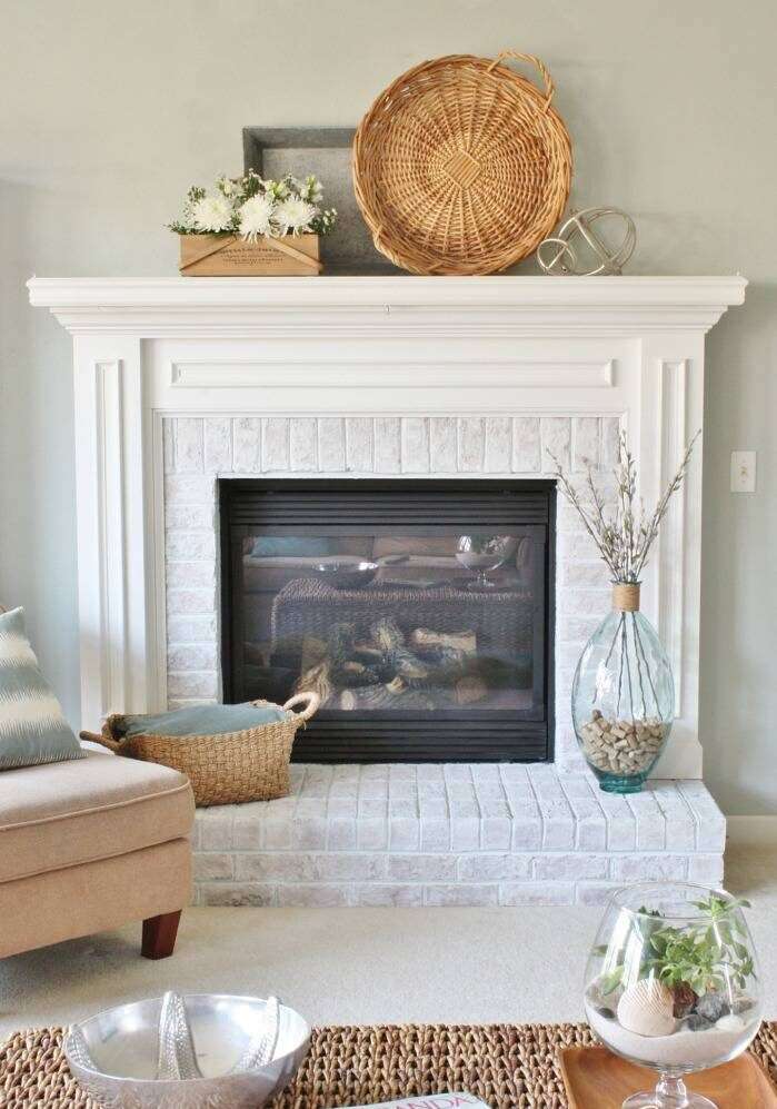 A modern living room with a whitewashed fireplace.