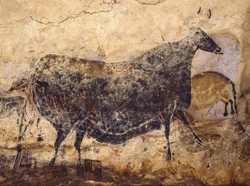 Ancient cave painting depicting a bull and other figures.