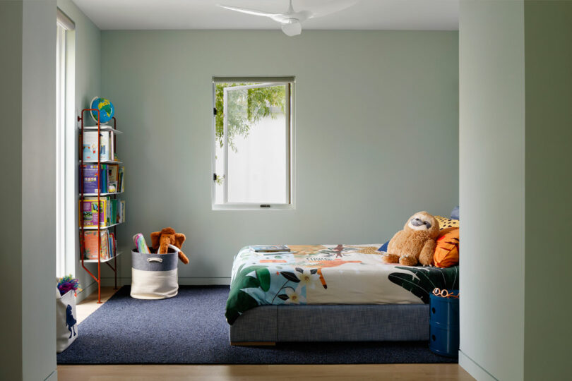 side view of a modern children's bedroom with colorful bed and bookshelf