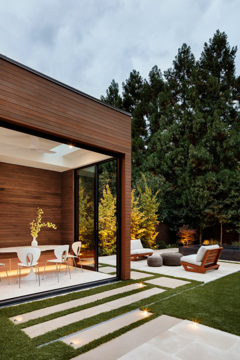 Modern backyard with a stylish patio, wooden deck, and landscaped garden.