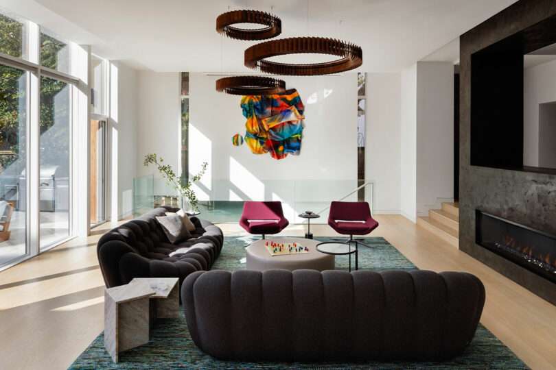 Modern living room with elegant furniture and colorful artwork.