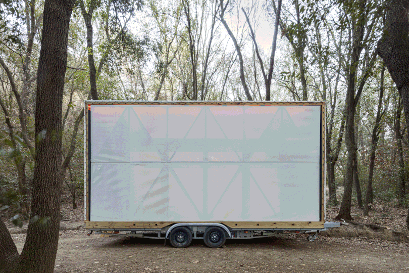 moving gif of a modern mobile home opening its side panel to reveal inside