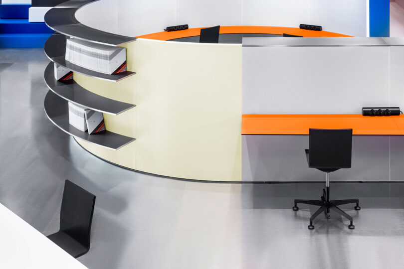 Modern office with a sleek, curved desk design and a monochrome chair.