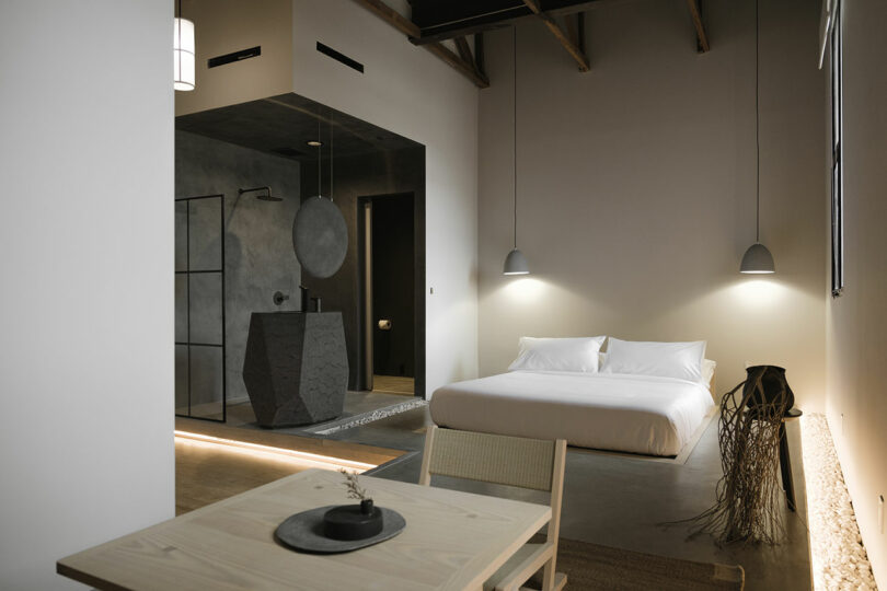 Modern bedroom with ensuite bathroom, featuring minimalist design and neutral tones.