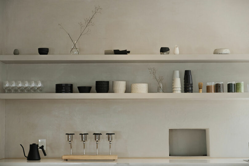 A minimalist kitchen shelves with neatly arranged dishes and decorative items.