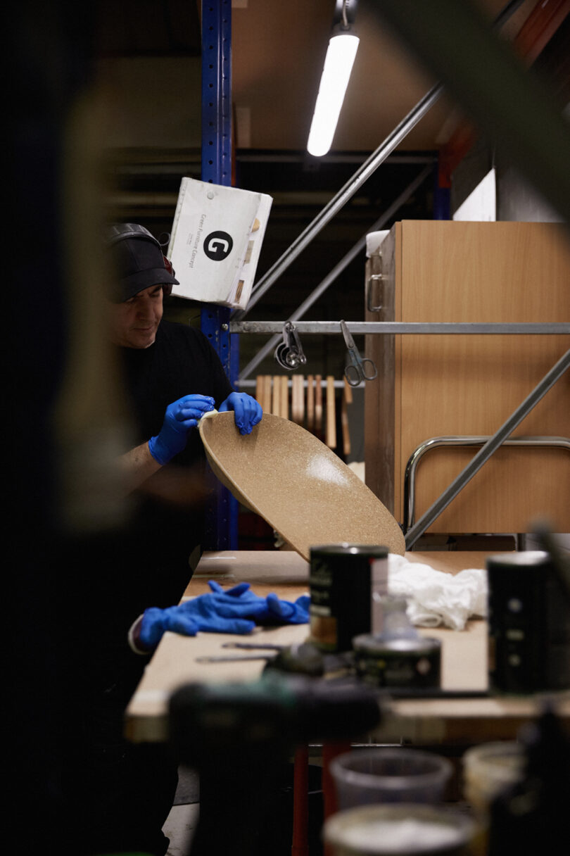 man oiling a chair shell in production facility