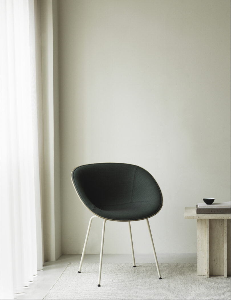 black upholstered shell chair next to side table