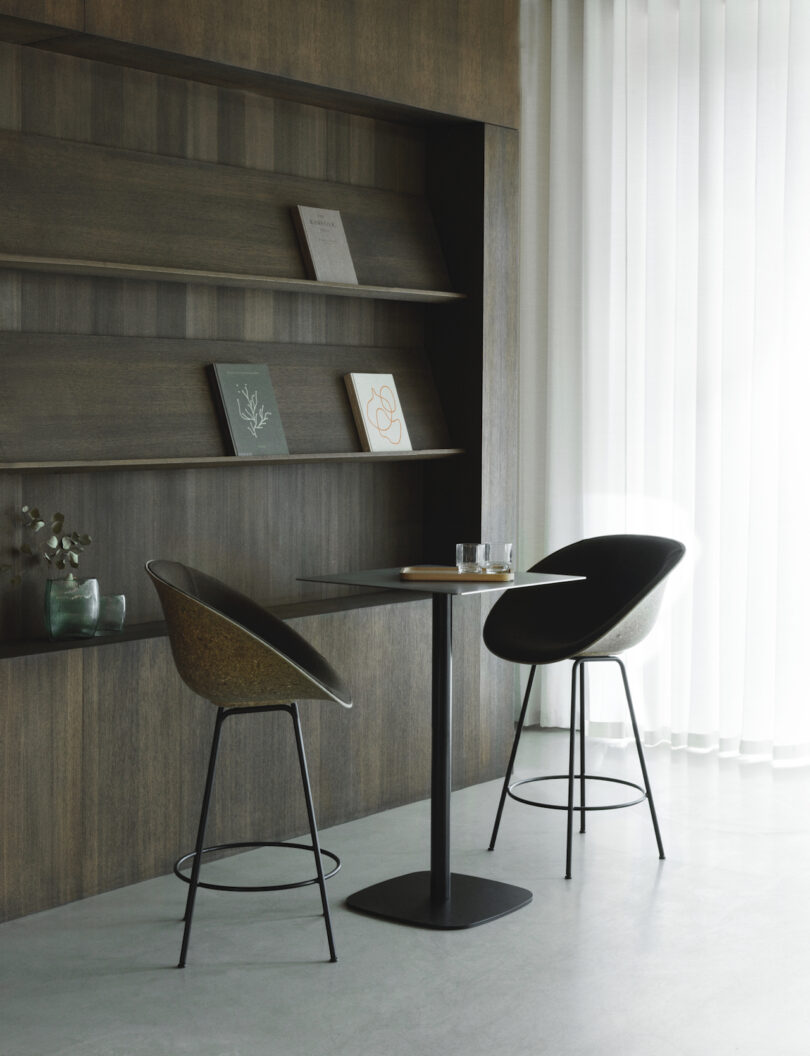 barstool shell chairs next to a shelf with books