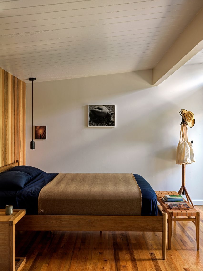 Bedroom with white-painted walls, ceilings and beams, plus wooden furniture