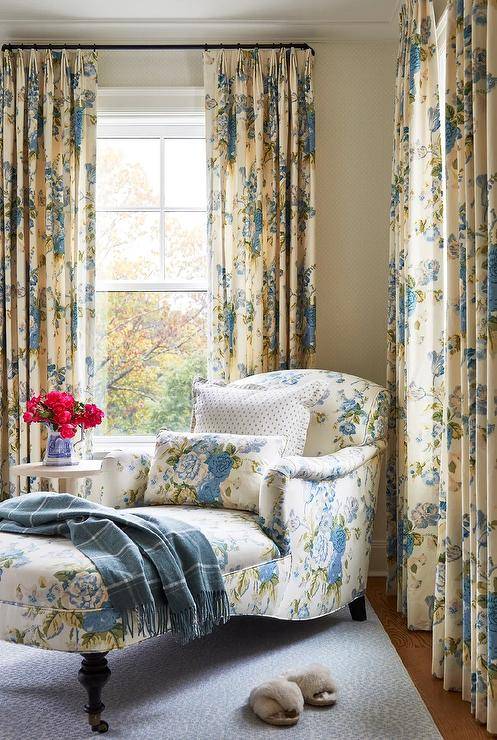 Bedroom features a yellow and blue floral chaise lounge with caster legs and yellow and blue floral curtains