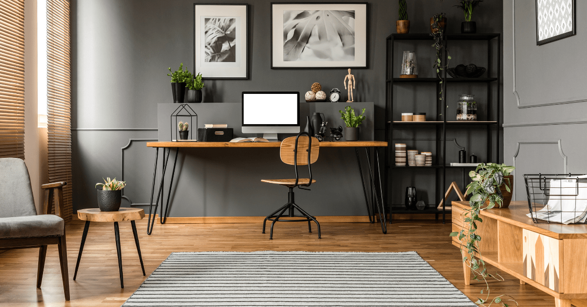 A small grey living room with wooden desk.