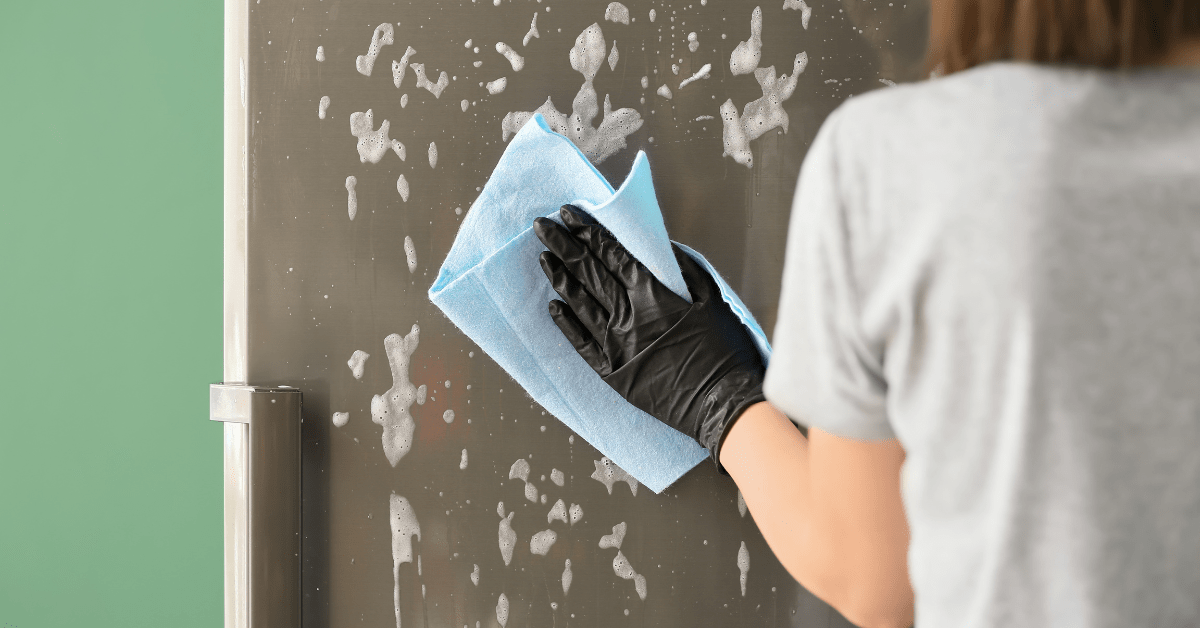 A person using a microfiber cloth to wipe off glass shower.