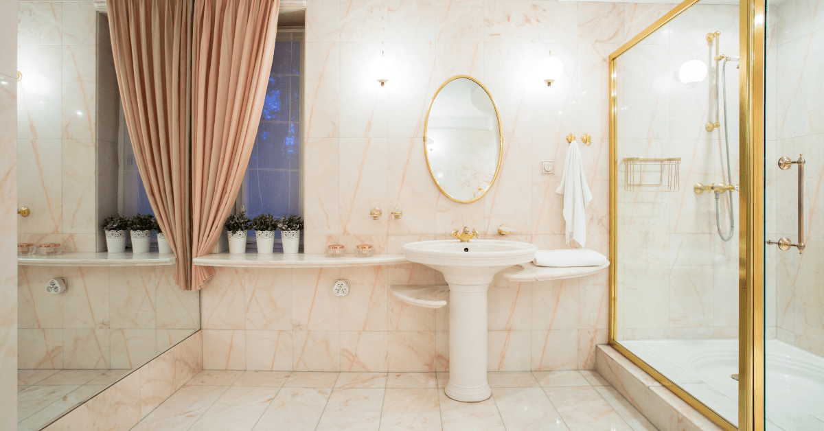 A bathroom with glass shower and metallic fixtures.