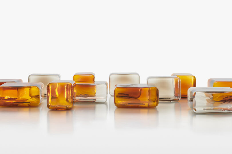 Rows of small, translucent and amber glass tables arranged neatly on a white surface.