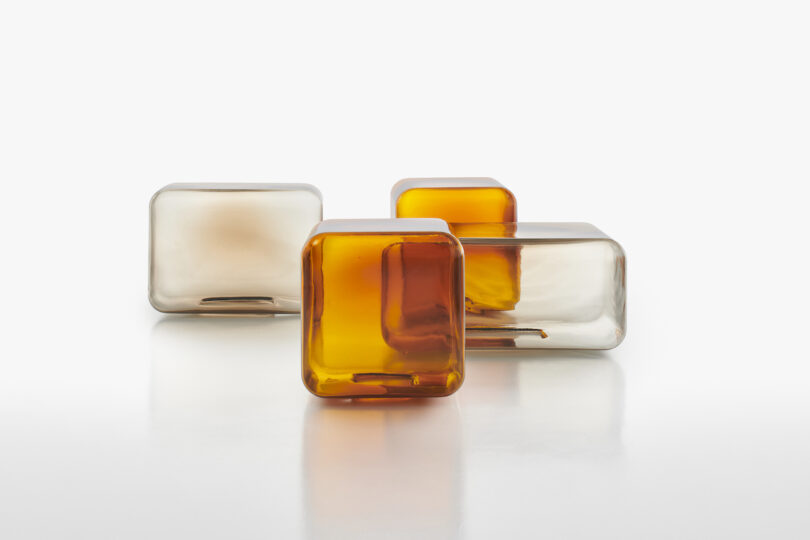 four translucent and amber glass tables arranged neatly on a white surface.