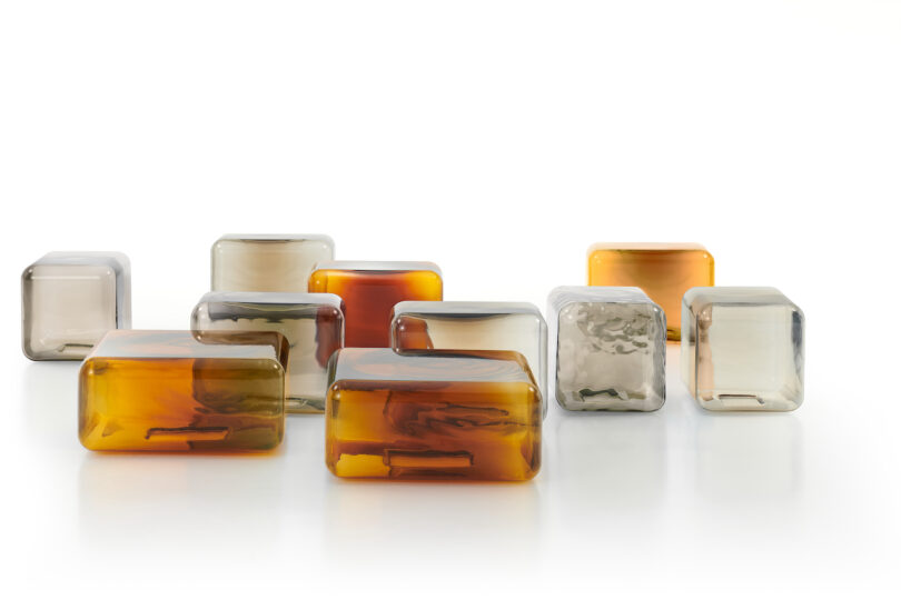 Rows of small, translucent and amber glass tables arranged neatly on a white surface.