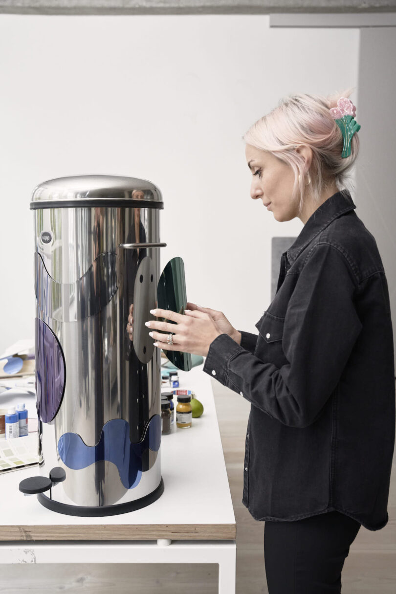 woman attaching magnetic shape to a steel trash can