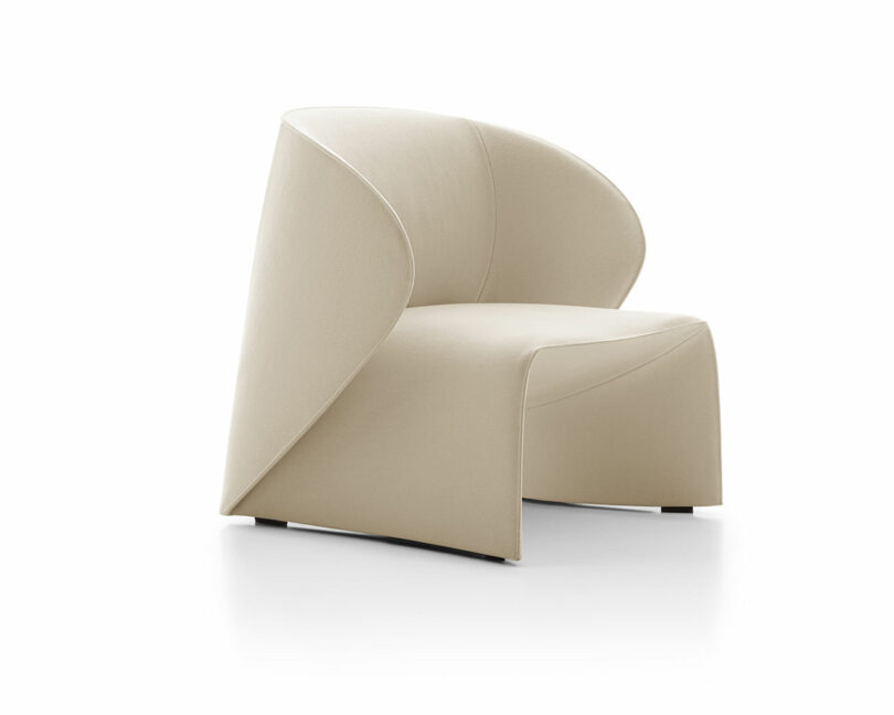 A modern, beige chair with a smooth, curved design and an open backrest, set against a plain white background.