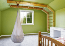 A fabric hanging chair in a green bedroom.