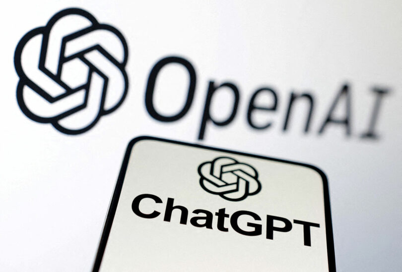 Close-up of the OpenAI logo and the text "ChatGPT" displayed on a smartphone and a larger screen in the background.