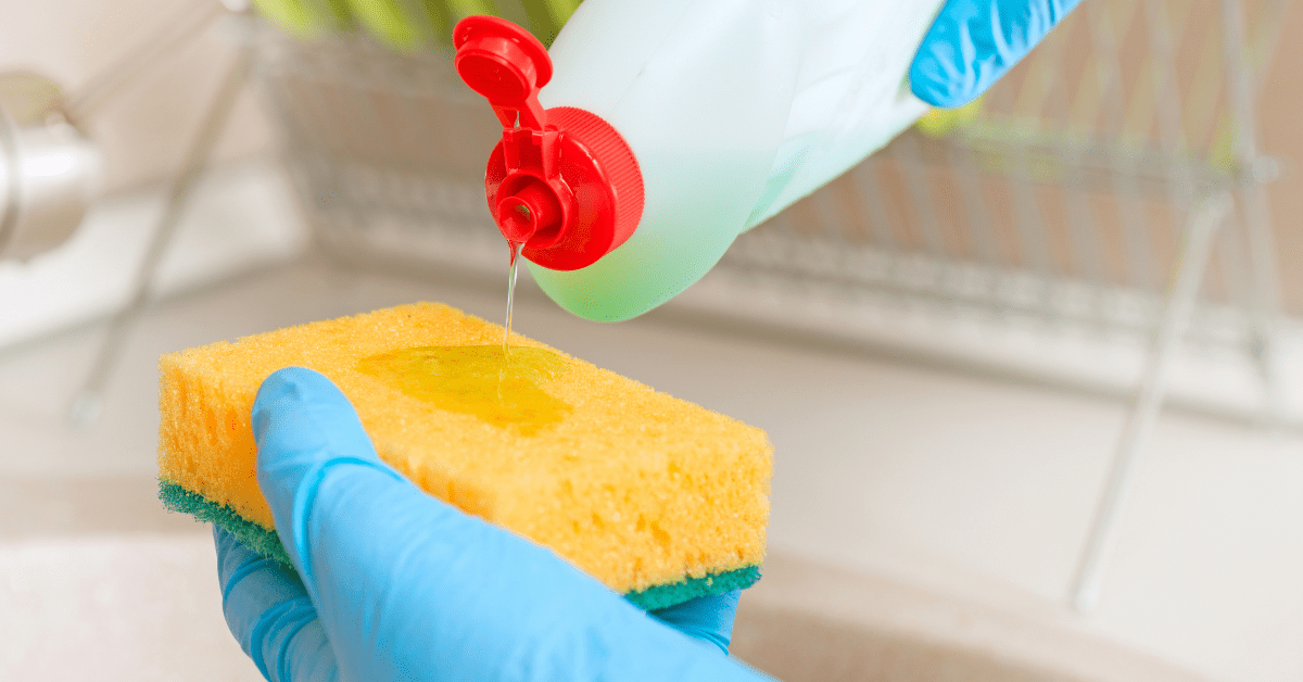 Person cleaning a sponge for dishes.