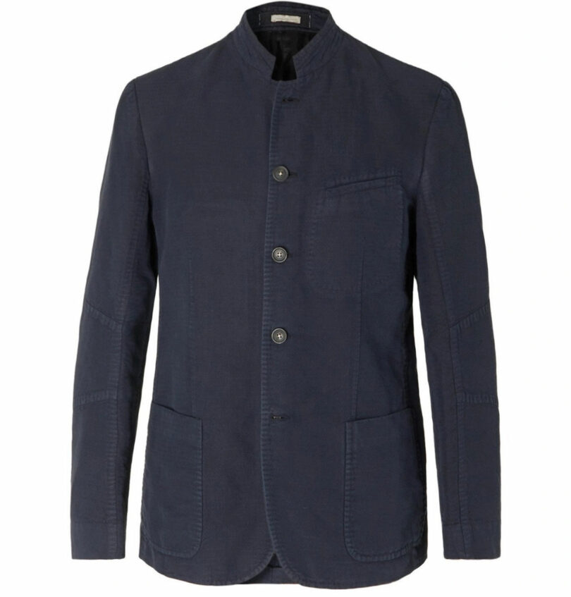 A navy blue blazer by Richard Parr with a mandarin collar and four buttons. It features two front pockets and a chest pocket, exuding elegance and timeless style.