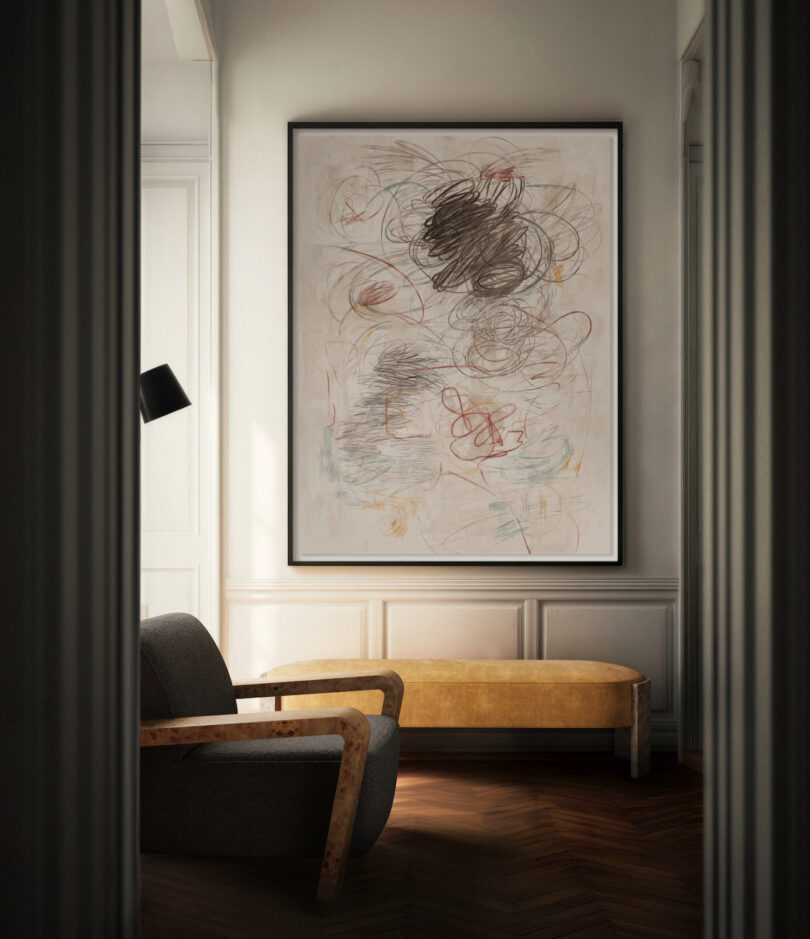 An abstract painting with scribbles hangs on a wall above a curved wooden bench. A modern armchair is positioned nearby in a sunlit room