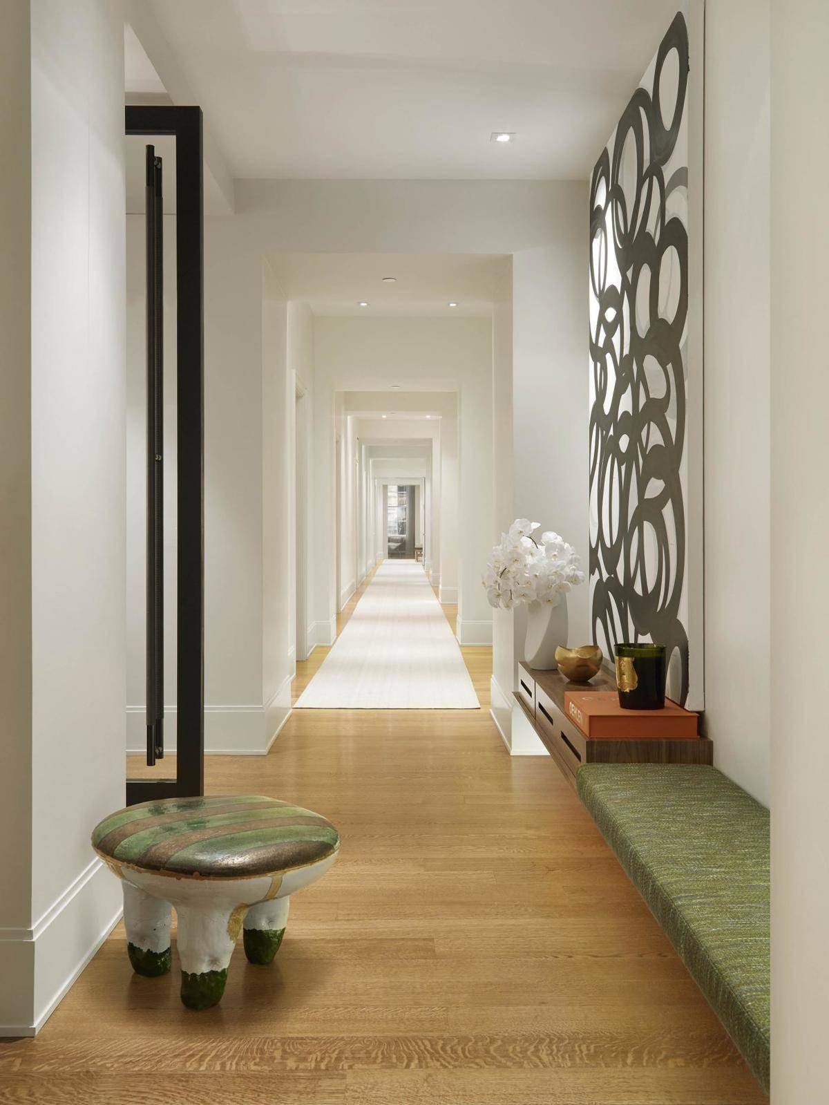 Long hallway with green furniture.