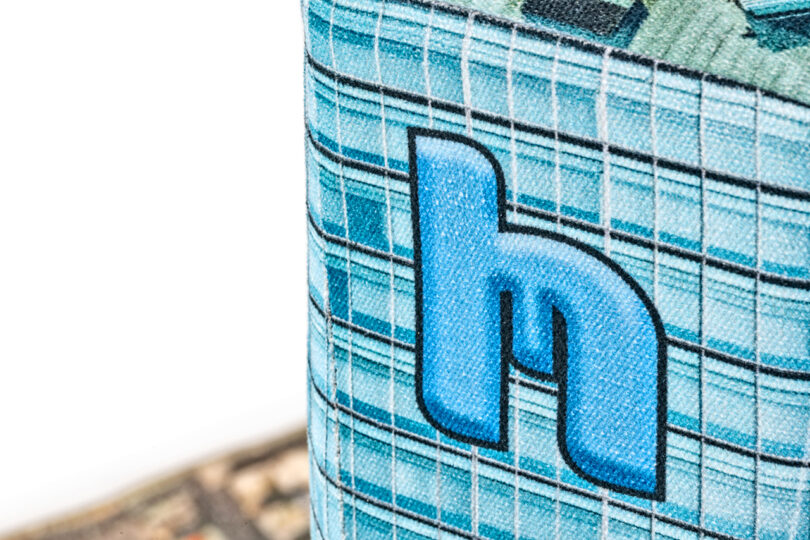 Close-up of a patterned fabric with a blue lowercase 